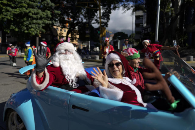 Un Santa Claus viaja en la parte trasera de un vehículo durante la carrera Santa Run 10K en Caracas, Venezuela, el 19 de diciembre de 2021. Esta es la primera Santa Run desde el comienzo de la pandemia. (Foto AP / Ariana Cubillos)